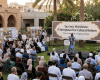 Speaker addressing an audience beneath a sign reading “‘Qur’anic Worldview’: A Springboard for Cultural Reform.”